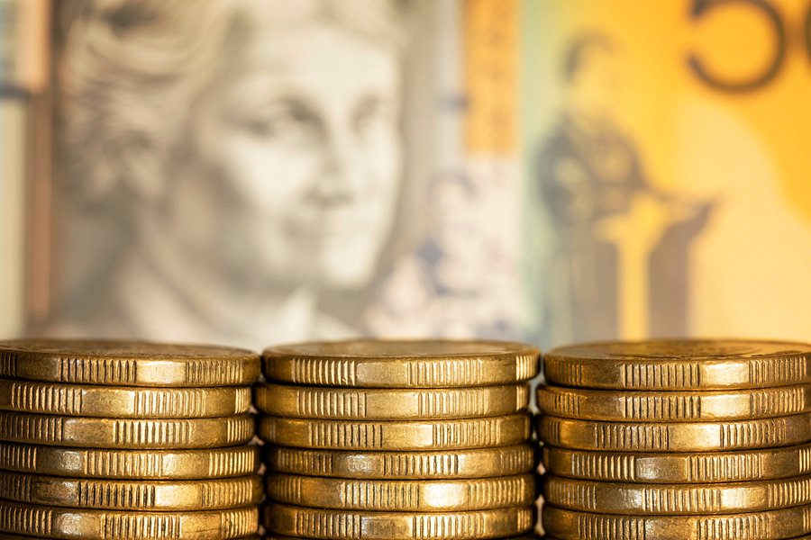 Stacks of Australian dollar coins over blurred money background.