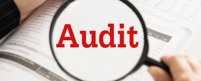 Audit concept. Auditor or IRS using magnifier auditing revenue in financial statement auditing tax process.